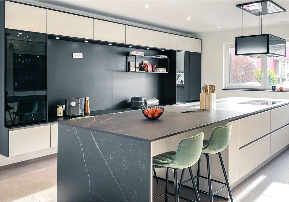 moderne grifflose Küche in beige mit marmorierter Arbeitsplatte und integrierter Wohnwand