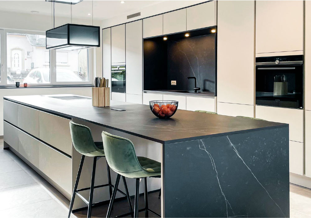 moderne grifflose Küche in beige mit marmorierter Arbeitsplatte und raumhohen Schränken